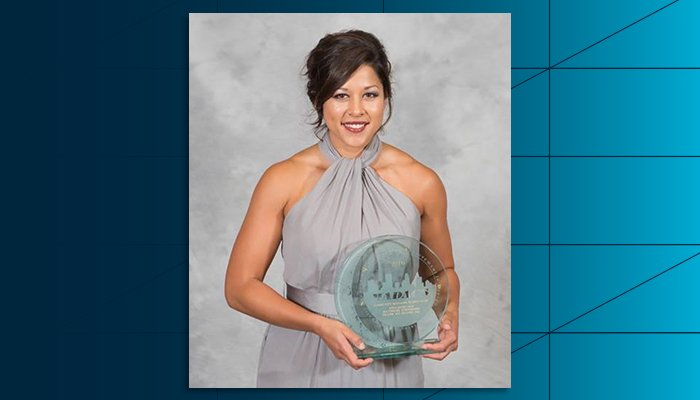 A portrait of Anna Javellana holding her manager of the year at the Minnesota Multi Housing Association’s 2016 MADACS Award.