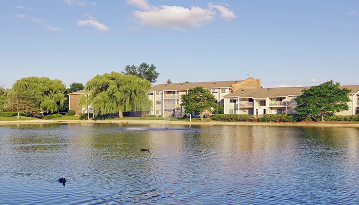 An exterior photograph of The Clayson, a 448-unit apartment community, from across a pond.