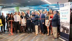 Draper and Kramer Mortgage Corp. employees cut the ribbon for the mortgage firm’s new headquarters in Downers Grove, Ill. during a grand opening celebration on August 22.