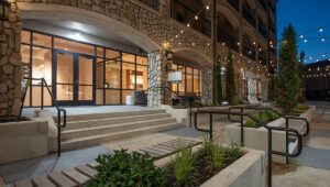 Looking down the porch of Bell Tower Flats which sits along the promenade at dusk with lights hanging above.
