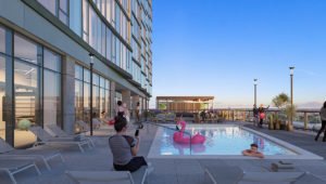 A rendering of the outdoor pool at Aspire Residences. People can be seen around the pool talking and one person is swimming. A pink flamingo float is in the pool.