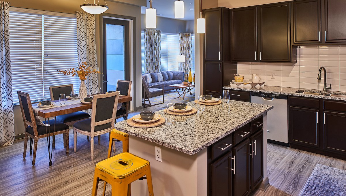 A kitchen island in a typical unit at EVO Living. A dining set is seen just on the other side and part of the living room can be seen past that.