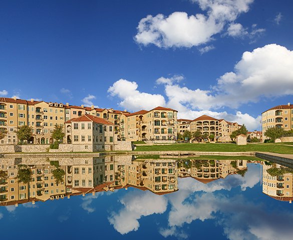 A view of Saint Paul's Square at Adriatica Village from across the lake, the water is so scene and clouds above reflect on the water like mirror.