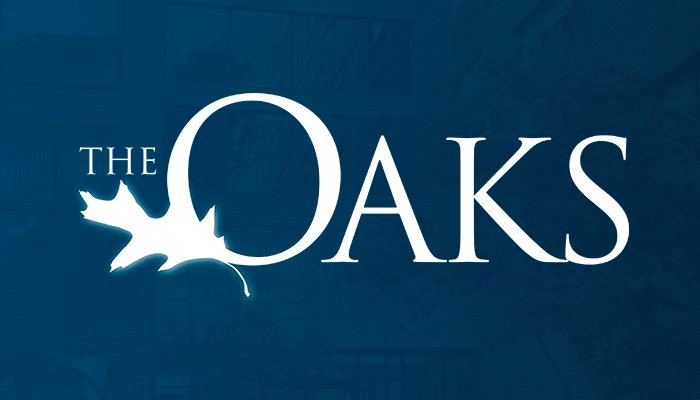 The Oaks logo presented on a blue background featuring "Oaks" written large with an oak leaf drawn on the lower left of the "O" with "The" printed above the leaf so the logo reads "The Oaks".