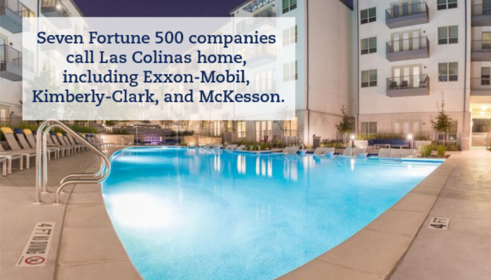A night photograph of the pool at Crest at Las Colinas Station apartments. The pool is a crisp blue and lit beneath the surface with the apartment building wrapping around it. A caption reads "Seven Fortune 500 companies call Las Colinas home, including Exxon-Mobil, Kimberly-Clark, and McKesson."