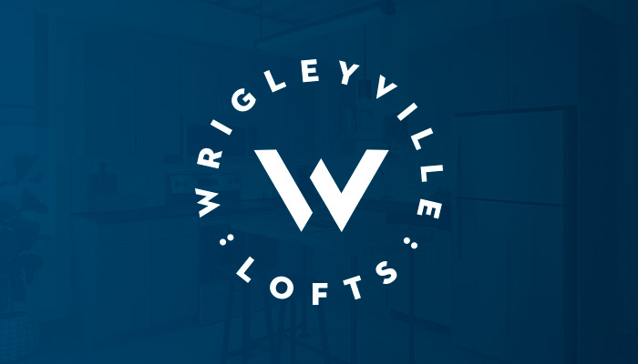 The Wrigleyville Lofts logo presented on a blue background. The logo features a "W" in the center with the name "Wrigleyville Lofts" circling around it.
