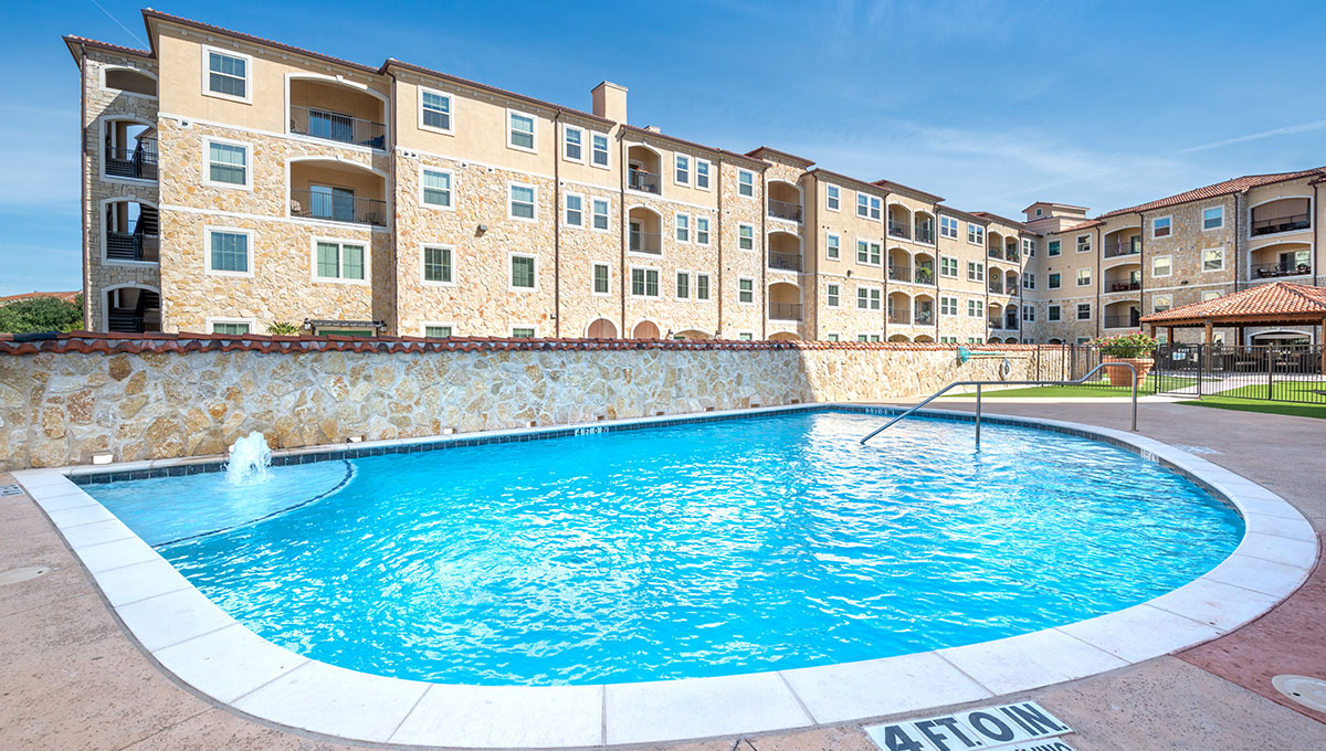 The outdoor pool at Adriatica Senior Living with the apartment building in the background.