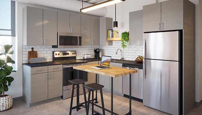 A rendering of a kitchen in a residence at Wrigleyville Lofts. A wooden island sit in the middle with stainless steel appliances and grey cabinets behind.