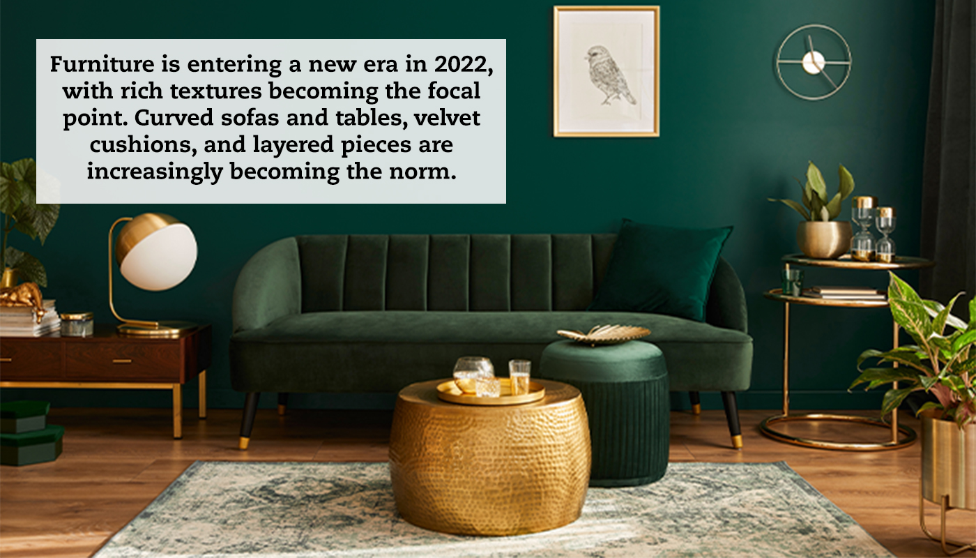 A living room set with a dark green couch against a dark green wall. A quote reads: "Furniture is entering a new era in 2022, with rich textures becoming the focal point. Curved sofas and tables, velvet cushions, and layered pieces are increasingly becoming the norm."