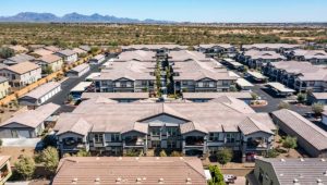 Looking down at a row of buildings in a column. There is desert beyond the column on a clear day.