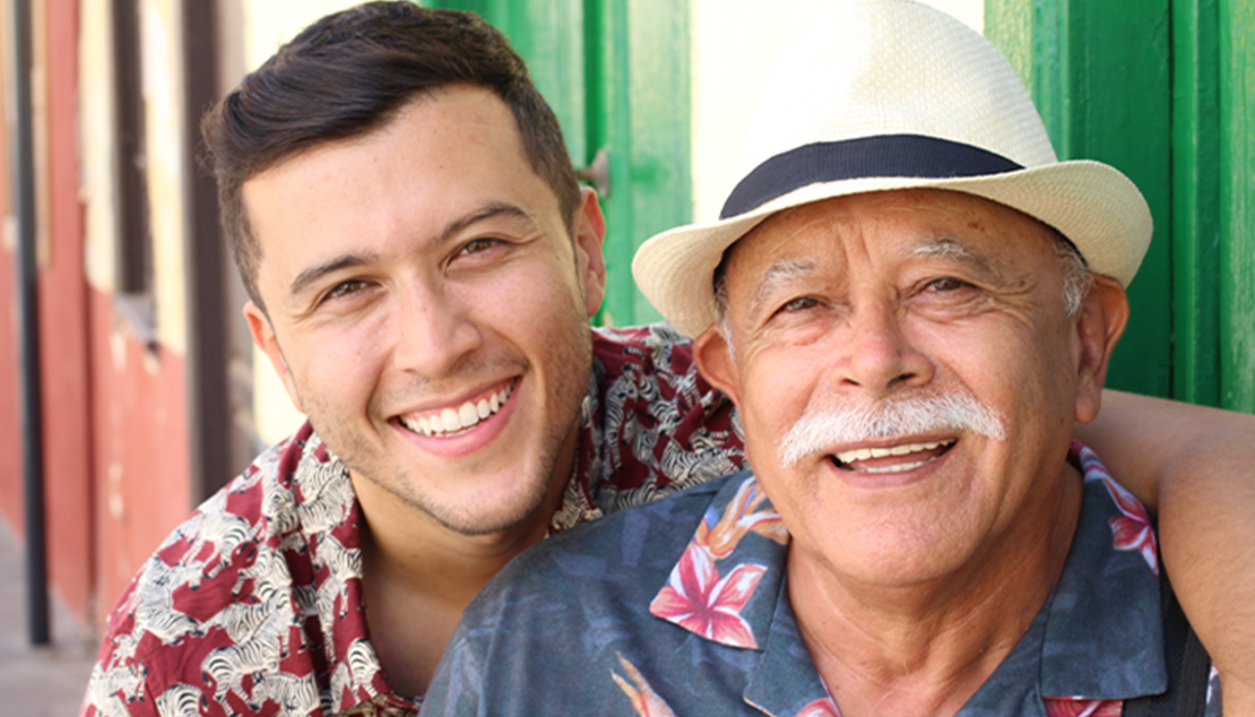 A Latino father and son smile for the camera.