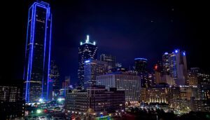 Looking at the Dallas skyline at night. Buildings a lit with with lights and the skyline glows.