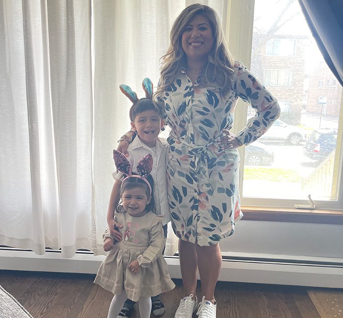 Brenda standing with nephew and niece in front of a window.