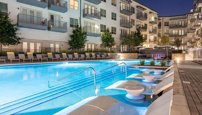 A swimming pool at an apartment complex at night.