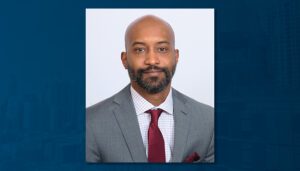 A portrait of Jesse Stewart IV on a blue background.