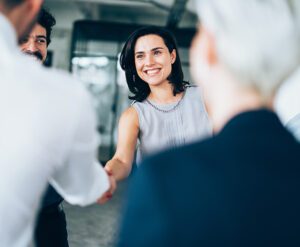 A group of business people shaking hands in an office.