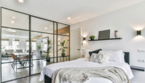 A bedroom with glass walls and a bed.