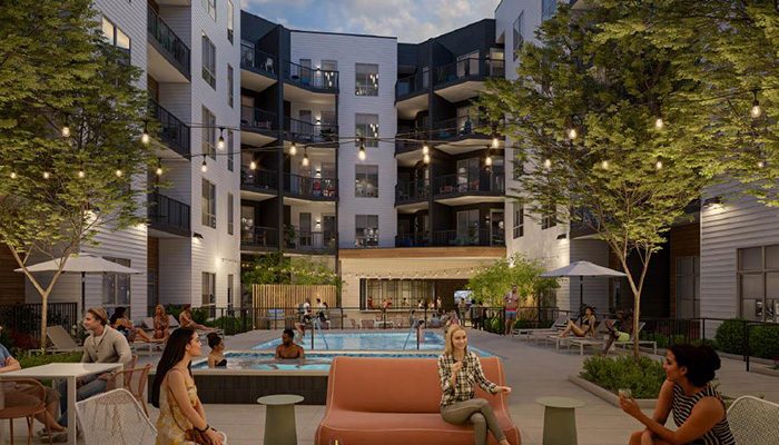 Evening view of the outdoor courtyard at Tempo Nine Mile Station in Aurora, Colo., featuring a resort-style pool, string lights, lush landscaping, and modern seating areas. Residents are seen socializing, relaxing by the pool, and enjoying the vibrant atmosphere.