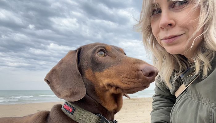 Hannah with Jimmy, her beloved dachshund, enjoying a peaceful day at the beach. Whether exploring Chicago or traveling the world, Jimmy is always by her side.