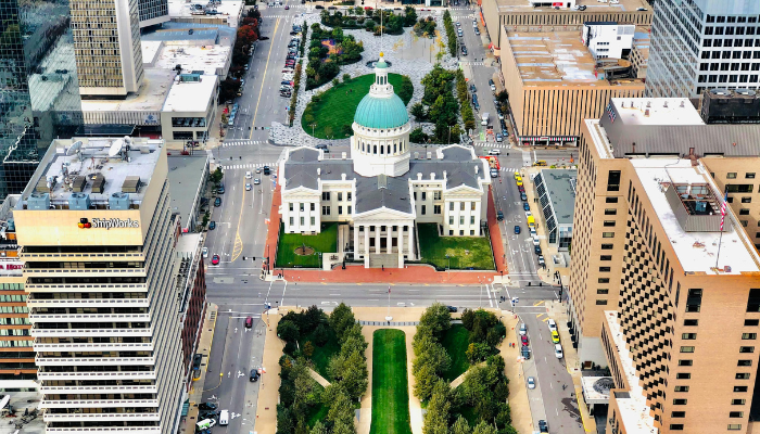 Aerial view of the historic Old Courthouse in downtown St. Louis, surrounded by modern office buildings and green spaces.