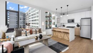 Open-concept Oak Park apartment at Eleven33 with modern kitchen, bar seating, and bright living area.