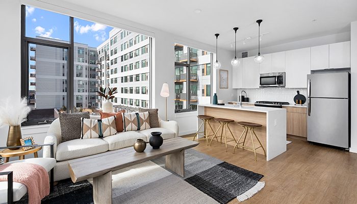 Open-concept Oak Park apartment at Eleven33 with modern kitchen, bar seating, and bright living area.