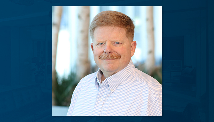 Professional headshot of Tim Kramer, vice president and director of operations at Draper and Kramer, wearing a light-colored button-down shirt and smiling against a blurred office background.