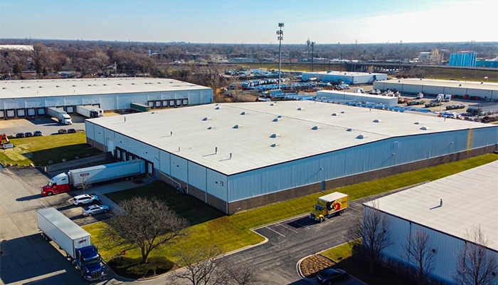 Aerial view of the fully leased industrial distribution complex in Bridgeview, Illinois, featuring multiple warehouse buildings, loading docks and parked trucks.