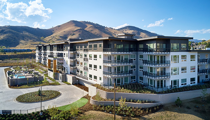 Aerial view of Epoque Golden apartments with balconies, outdoor pool, landscaped grounds and surrounding foothills.