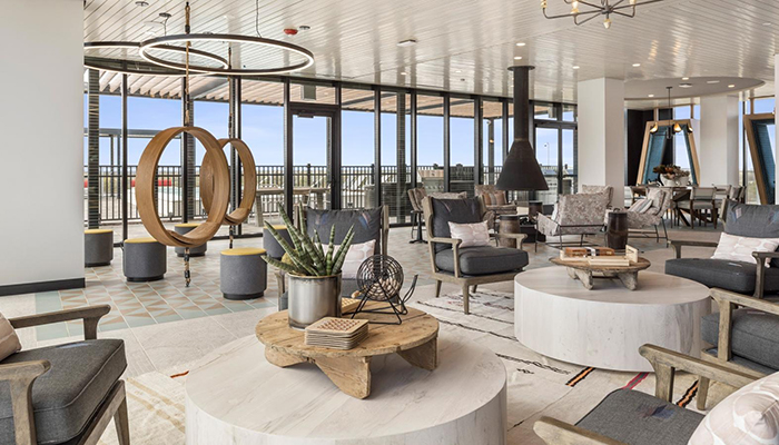 Rooftop sky club at Eva in downtown Evanston, featuring contemporary lounge seating, modern lighting, floor-to-ceiling windows and access to an outdoor terrace.